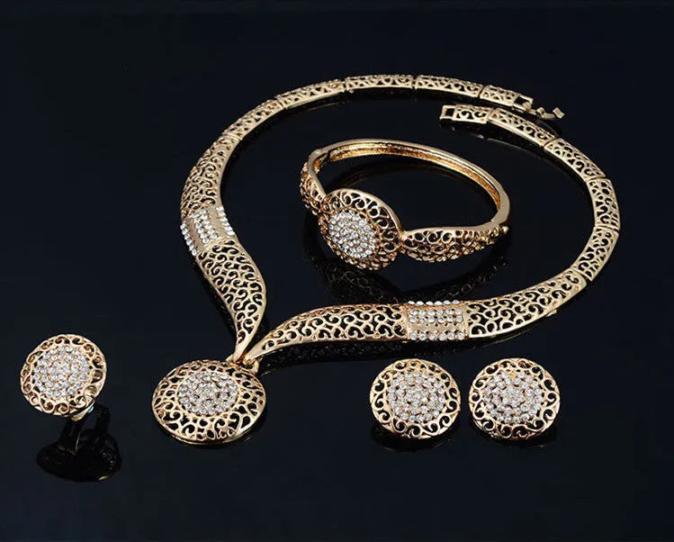 Gold jewellery four piece set with necklace, earrings, ring, and hand accessories featuring alloy and artificial gems