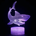 3D blue shark LED table lamp on a desk with colourful glow, showing remote control.