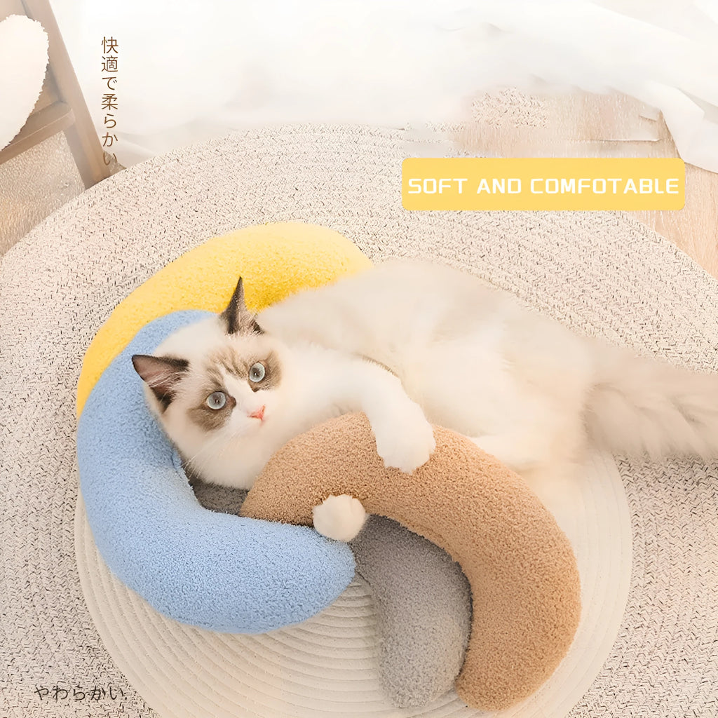 Blue U-shaped cat pillow with adjustable neck collar on sofa