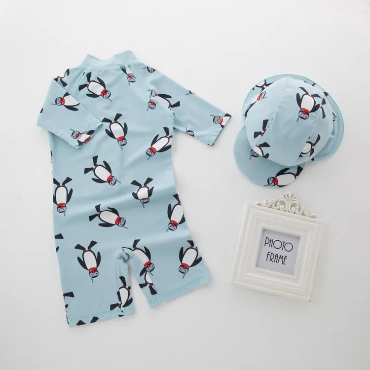 Boys' long-sleeve penguin print swimsuit set with matching swimming cap on mannequin
