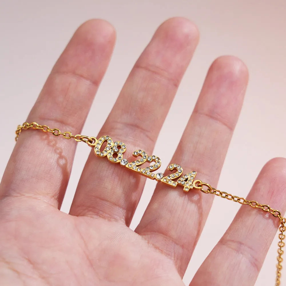 Stainless steel digital bracelet with diamond-set numbers on display, shown in gold tone.
