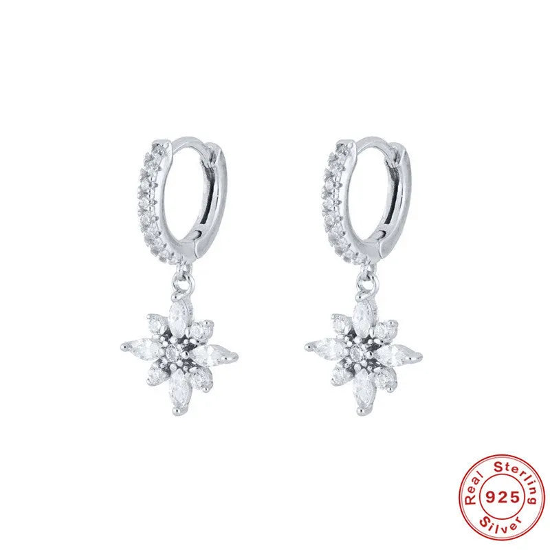 Pair of Sterling Silver snowflake pendant earrings on a yellow or white gold colour background.