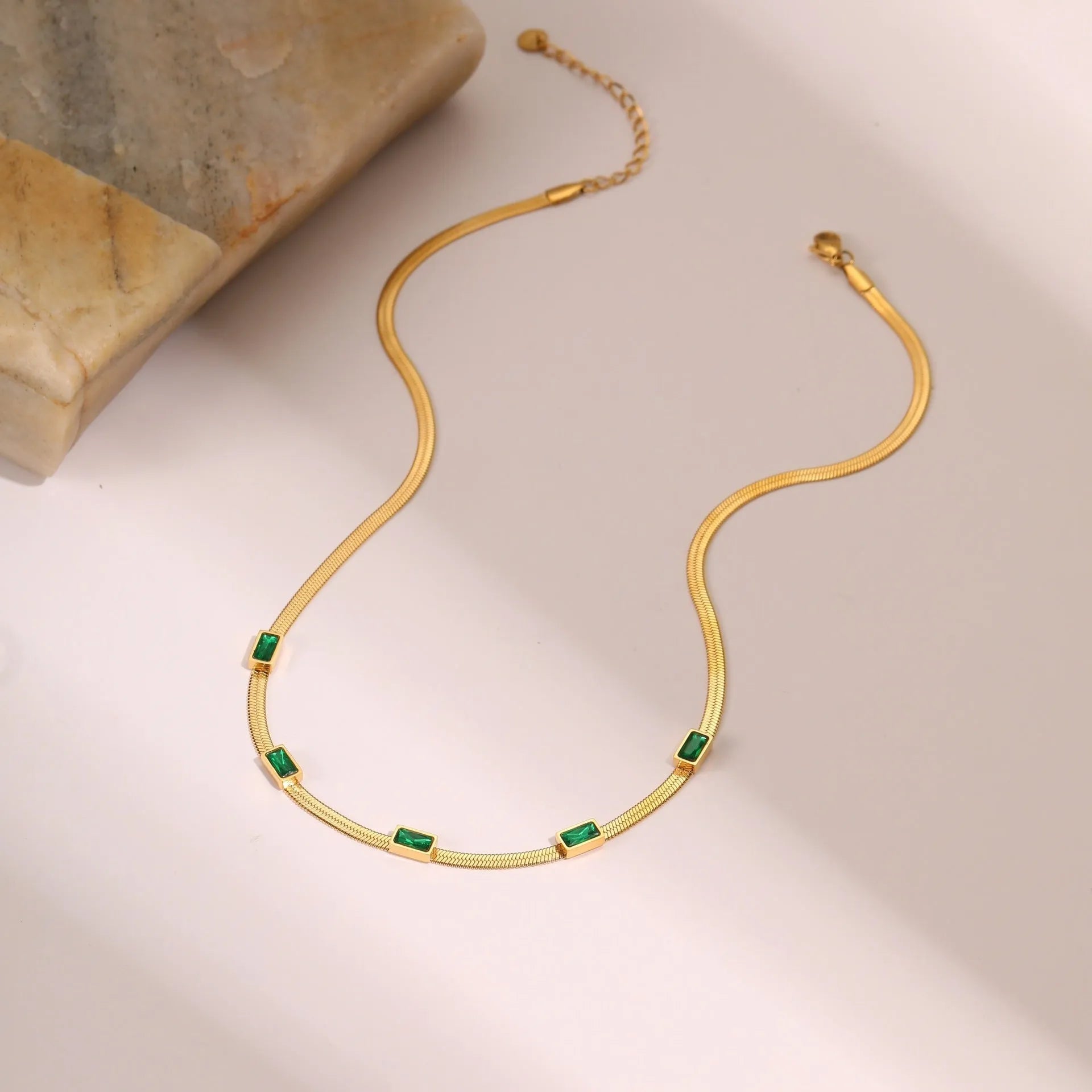 Retro geometric square zircon pendant on a stainless steel flat snake chain necklace in a gold colour finish.