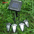 Four black bear paw-shaped solar garden lights connected to central solar panel pole
