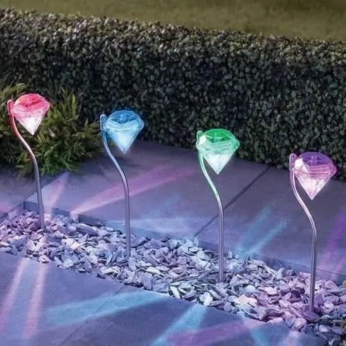 Solar powered diamond-shaped garden spotlight with adjustable angle on a grassy lawn.
