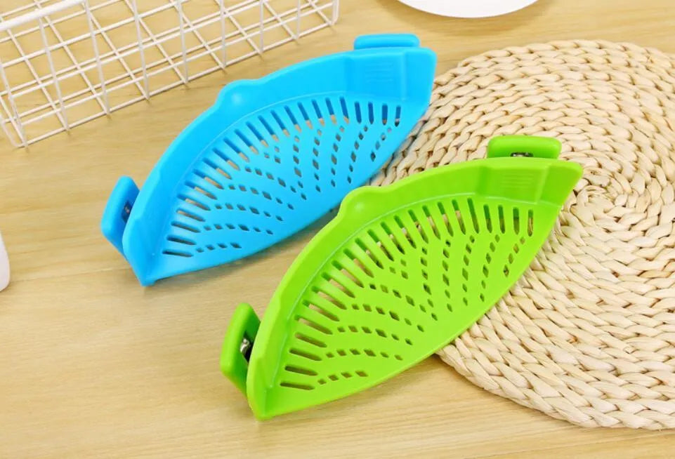 Silicone clip-on colander with stainless steel buckle attached to a pot, draining liquid, available in four colours.