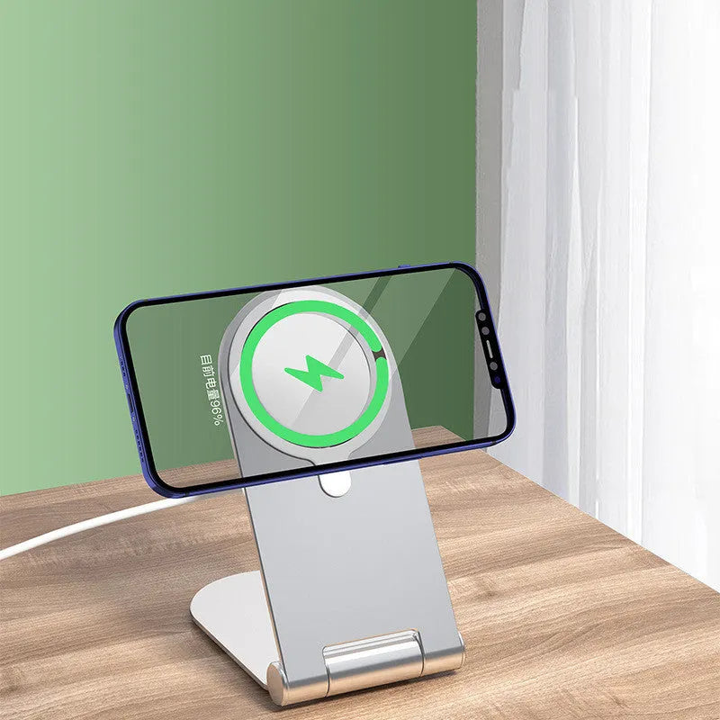 Silver vertical adjustable magnetic phone bracket for iPhone 12 models on a flat surface.