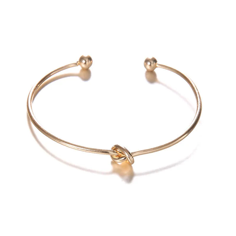 Gold vintage cuff bracelet for women with an arrow and knotted design detail.