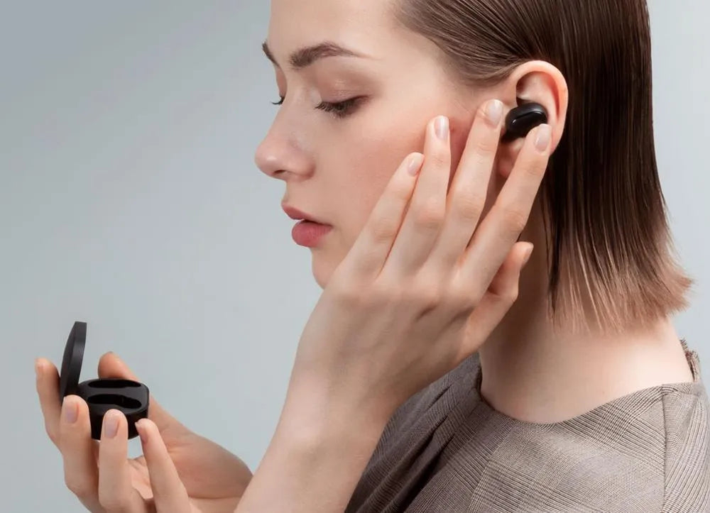 Redmi AirDots black true wireless earbuds and their compact charging case on a white background.