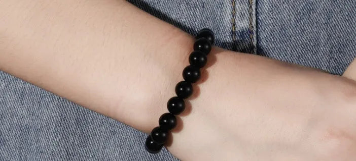 Black agate stretch bracelet with 8mm geometric beads on a black elastic cord.