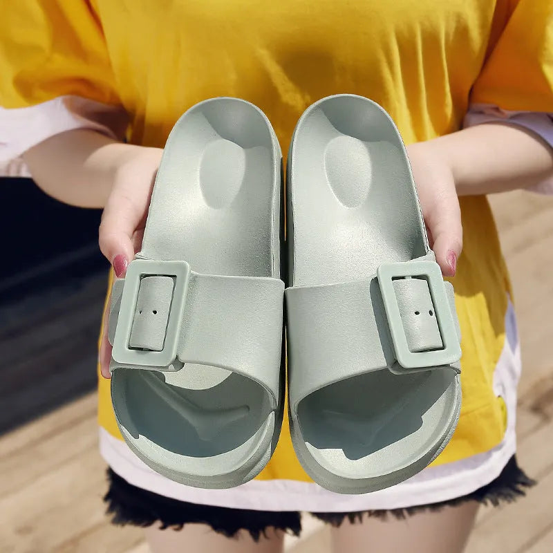 Women's grey blue buckle slipper made of soft EVA material on a plain background