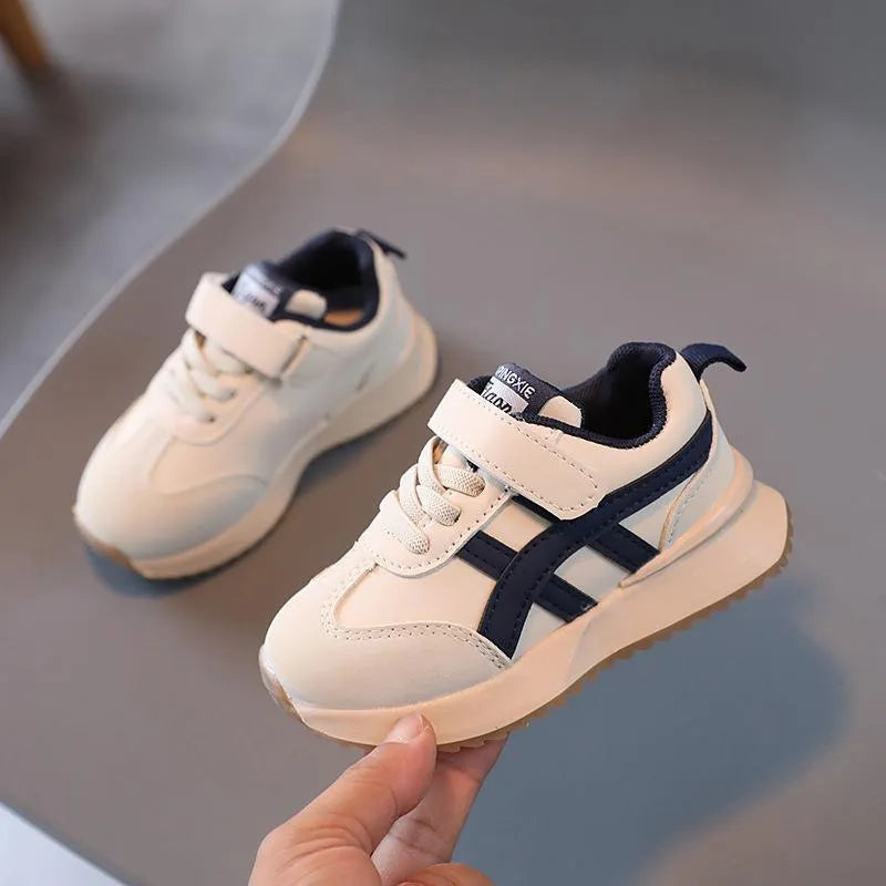 Children's white casual sneaker with Velcro closure showing synthetic leather upper and rubber sole