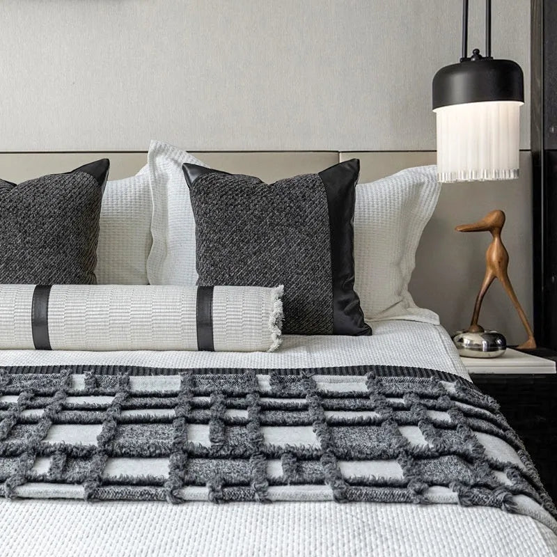 Modern minimalist grey and white plaid bed runner blanket set with matching pillow on a bed.