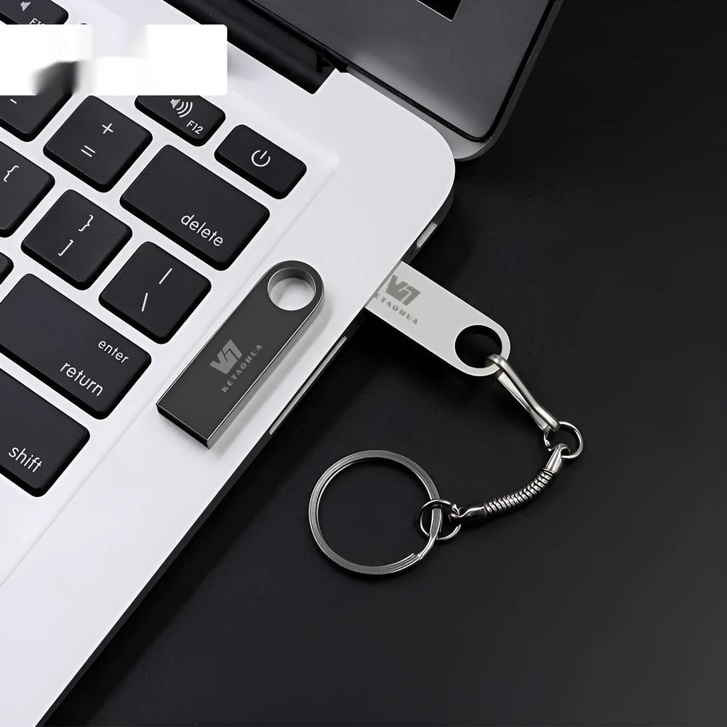 Silver metal car-shaped USB flash drive on a white background.