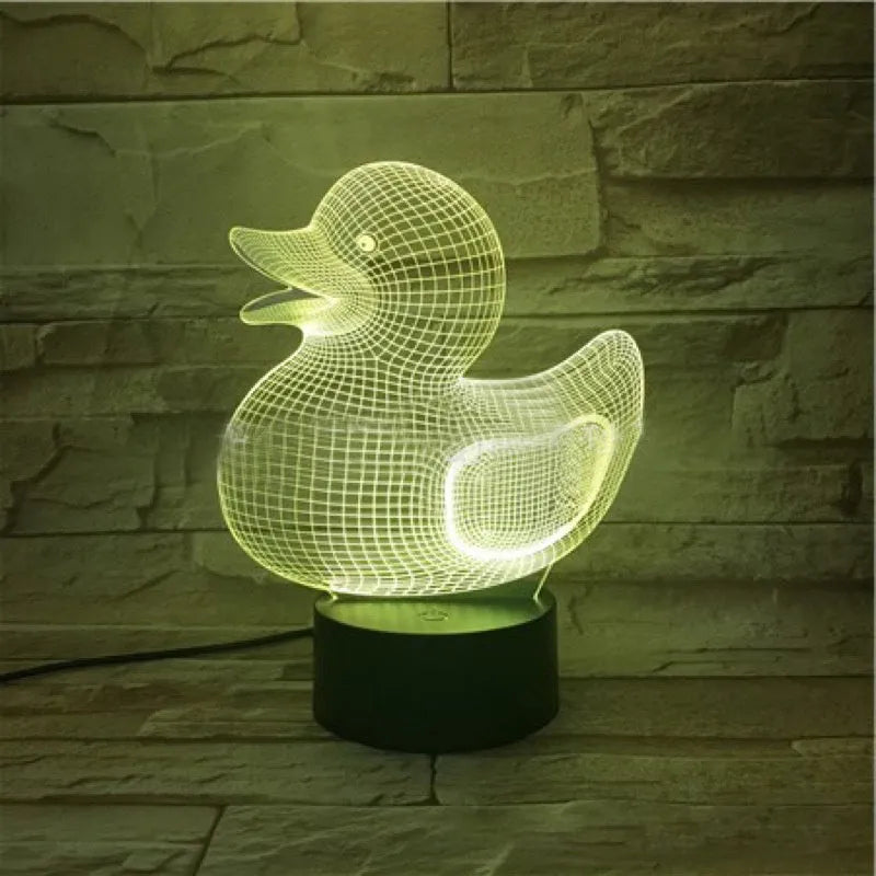 3D Little Yellow Duck night light glowing in multiple colours on a desk with remote control.