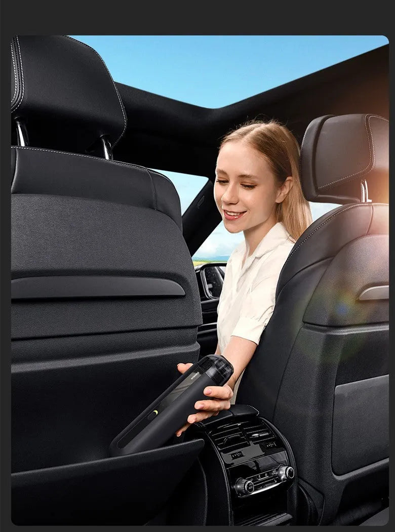 BASEUS wireless handheld car vacuum cleaner in black on a car seat, showing compact size and nozzle attachment.
