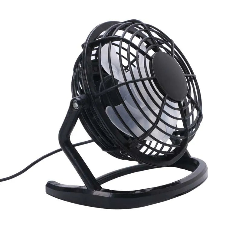 Mini adjustable USB desk fan in black on a desk next to a laptop