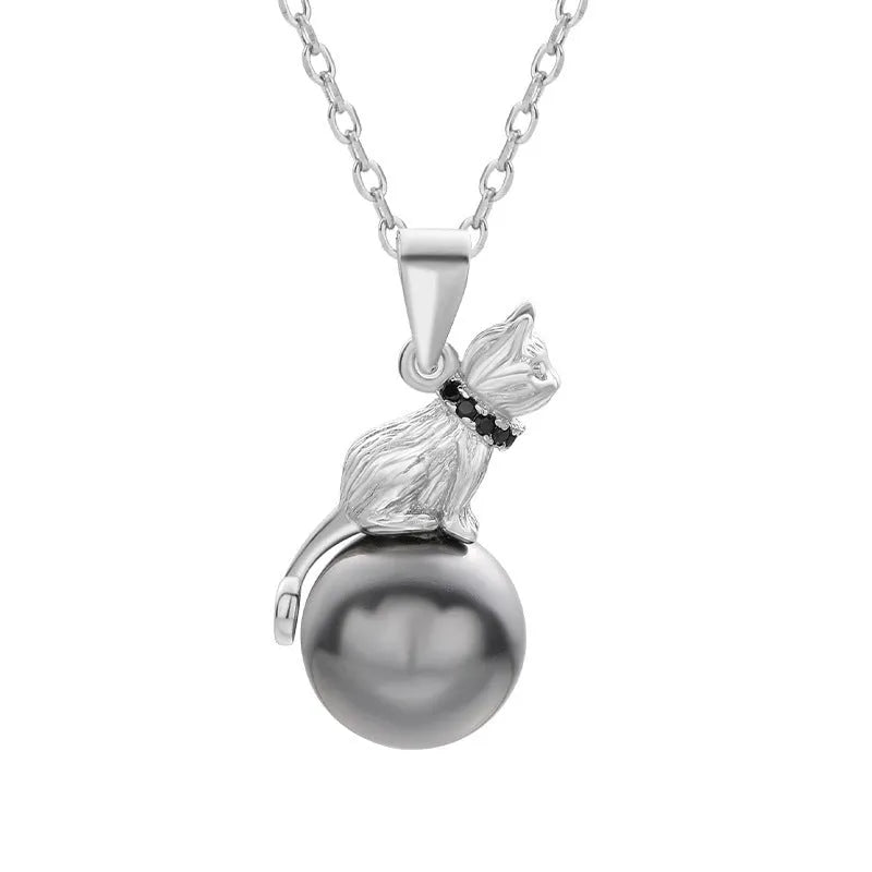 Close-up of a sterling silver cat pendant on a delicate clavicle chain necklace.