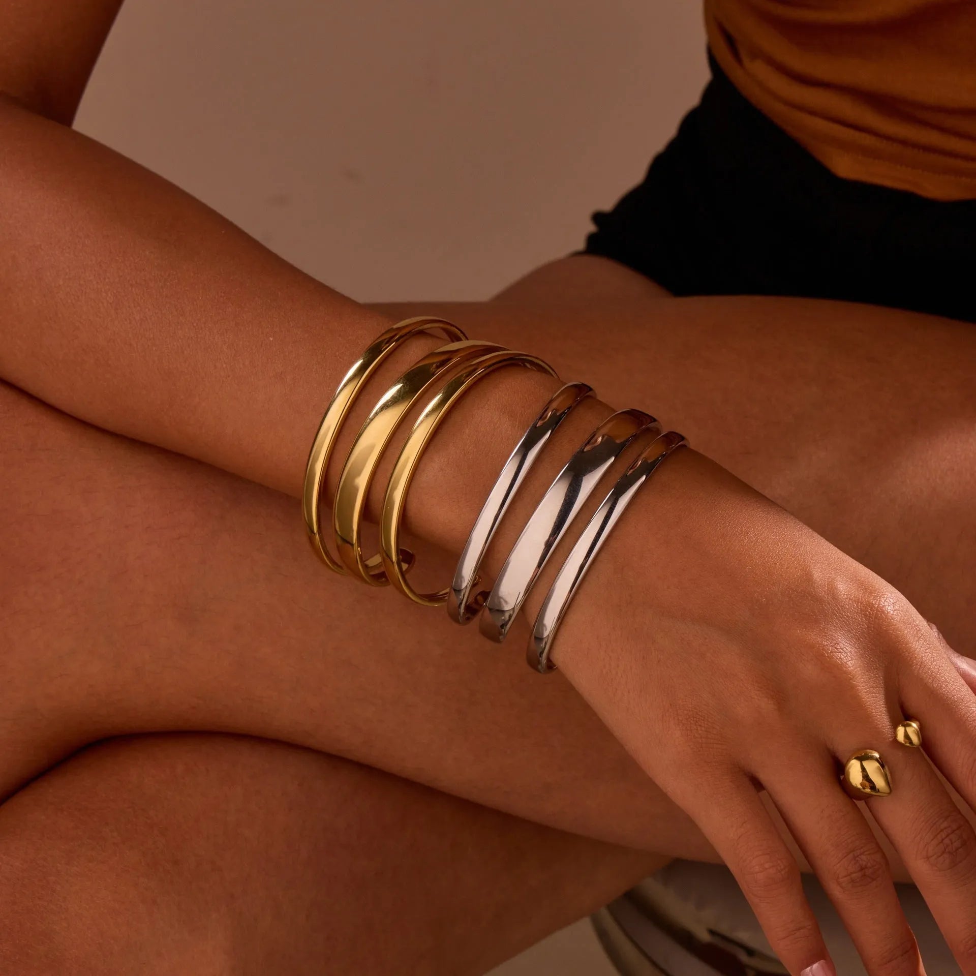 A simple open geometric stainless steel bracelet for women, shown in a gold tone finish.