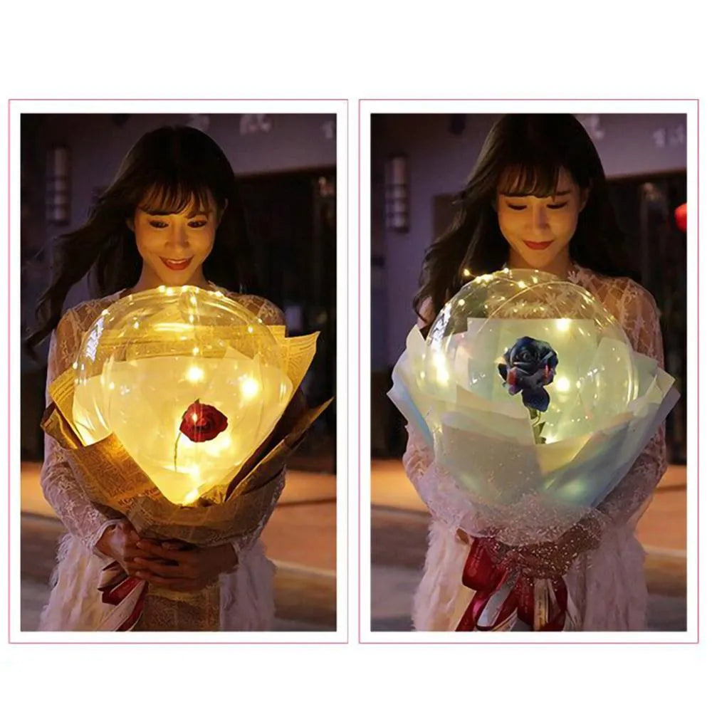 Transparent LED balloon rose bouquet with pink artificial flower and glowing light on dark background