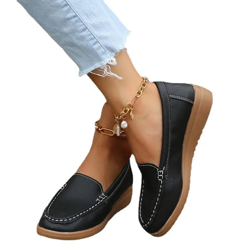 Women's black PU leather flat loafer shoes with a round toe and car suture detail on a white background.