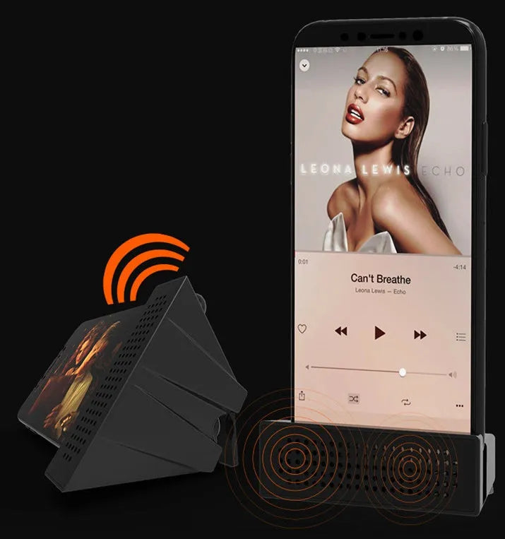 Portable black ABS plastic phone amplifier holder with an iPhone inserted, shown on a desktop.