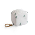 A plain blue cloth cube-shaped makeup storage bag on a table.