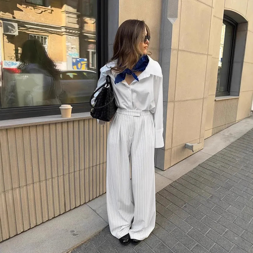 White striped wide-leg trousers with a zip fastening, laid flat.