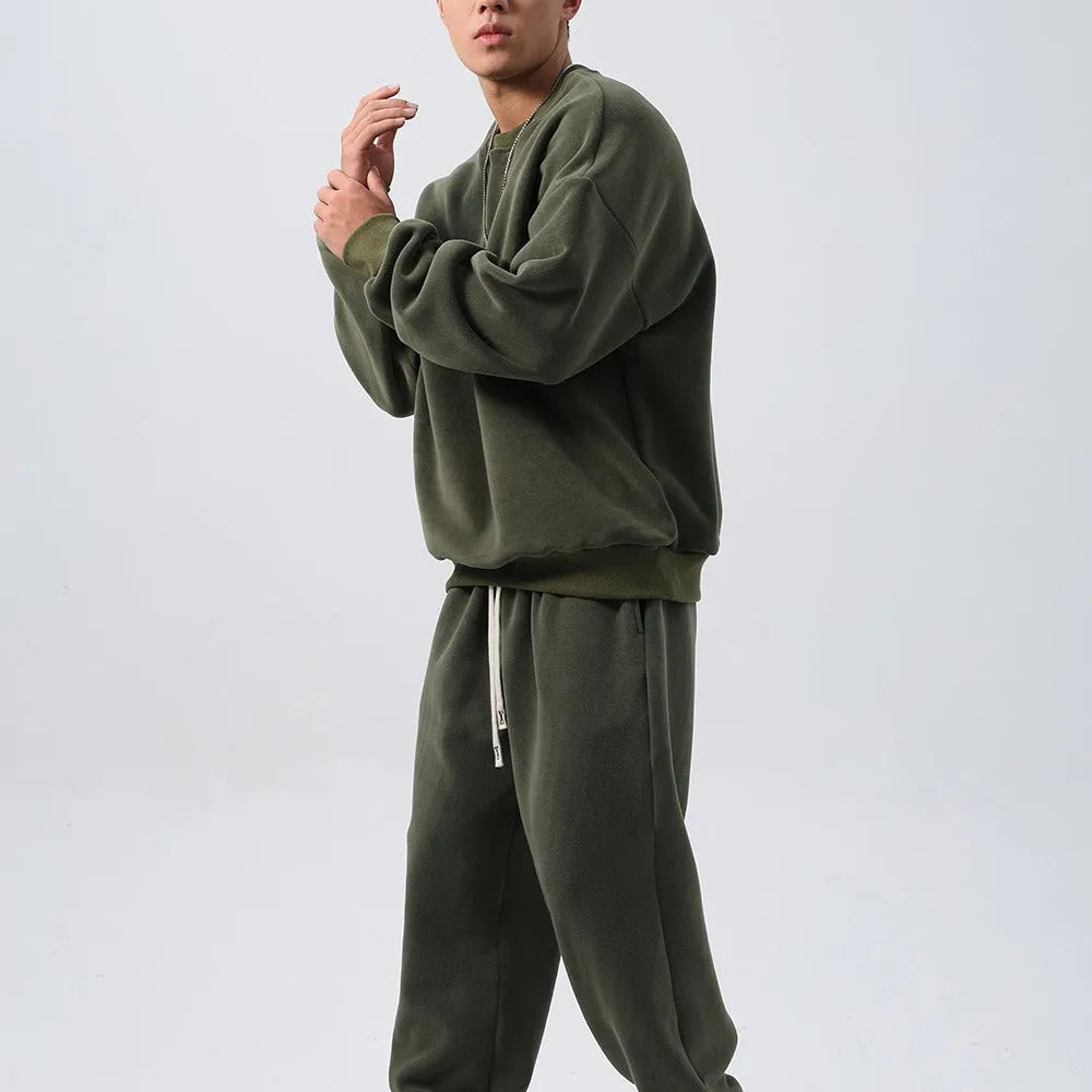 Man wearing a black loose-fit polar fleece sports suit with crew neck top and padded trousers for winter.