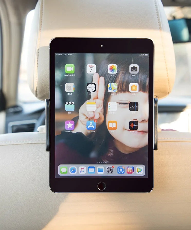 Black plastic car phone holder mounted on rear seat base holding a tablet for navigation