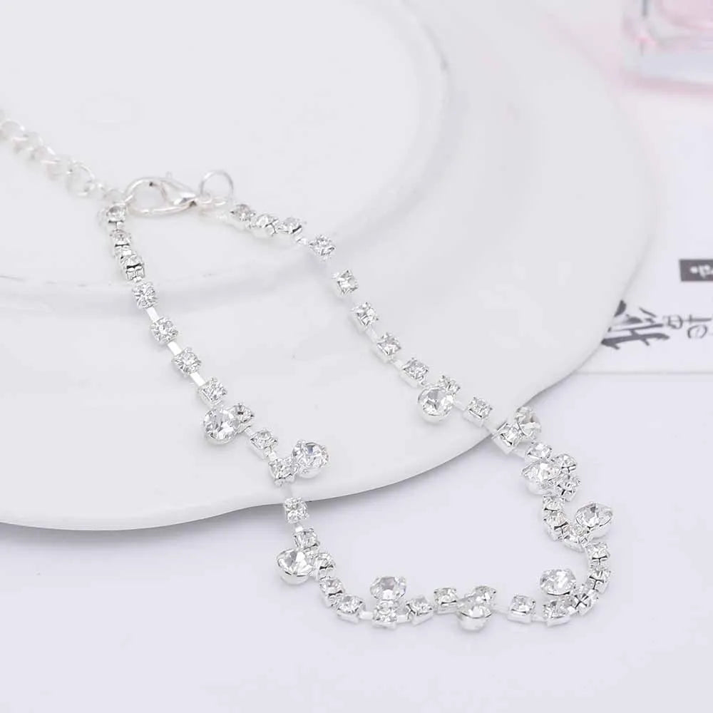 Silver alloy women's anklet with water drop tassel and stone inlay on a white background showing chain and clasp