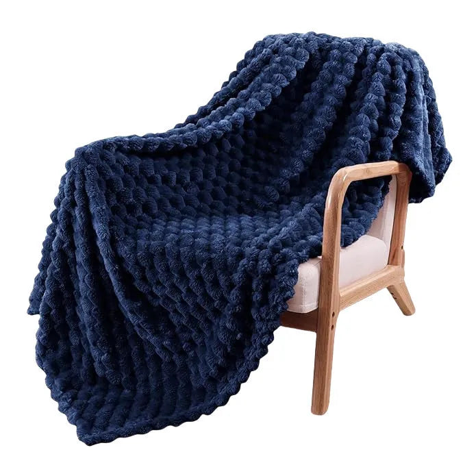Children's soft polyester plaid blanket in camel colour, folded on a bed