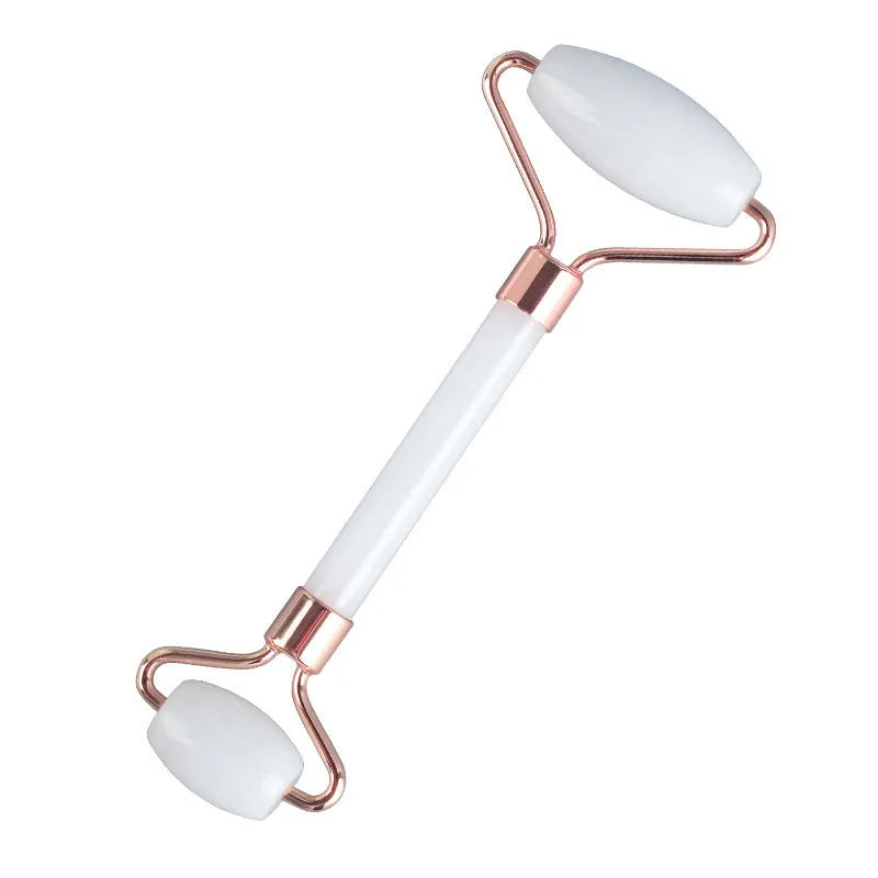 White jade double-headed facial roller and gua sha scraping board set on a storage tray.