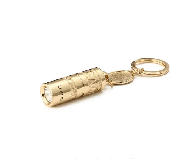 Gold-coloured waterproof mini LED flashlight on a keychain ring.