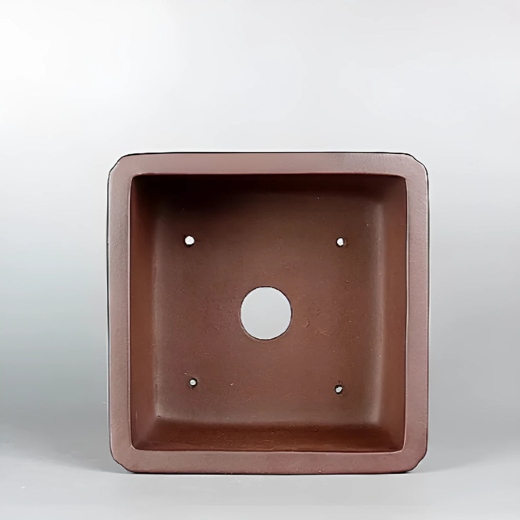 Handmade brown antique purple clay flower pot for desktop plants.