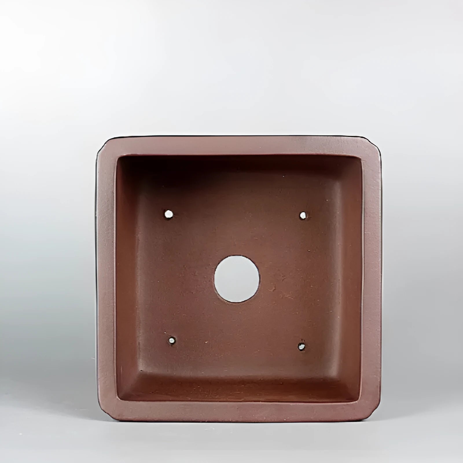 Handmade brown antique purple clay flower pot for desktop plants.