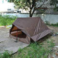 Brown A-frame hiking tent supported by hiking poles showing spacious interior for 2-3 campers