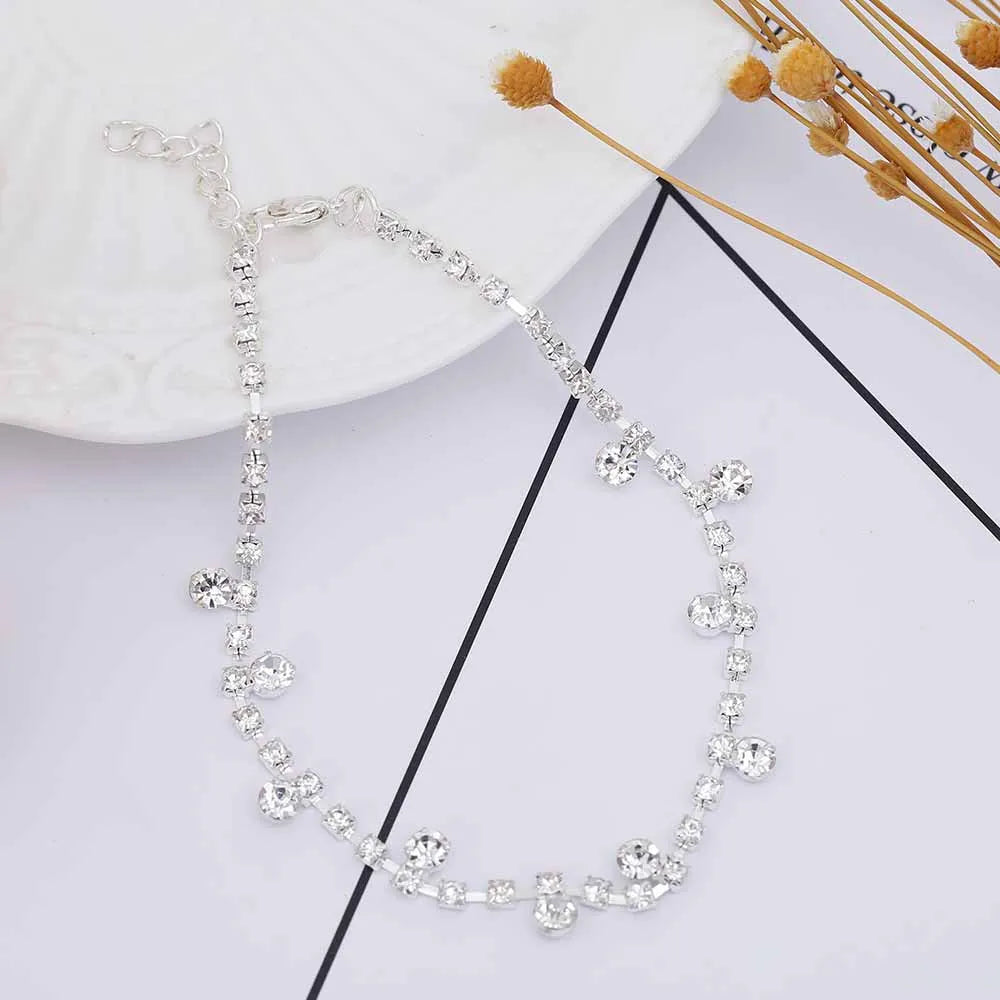 Silver alloy women's anklet with water drop tassel and stone inlay on a white background showing chain and clasp