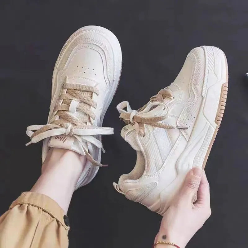 Women's low-top pink and white sneakers with a rubber sole and imitation leather lining.