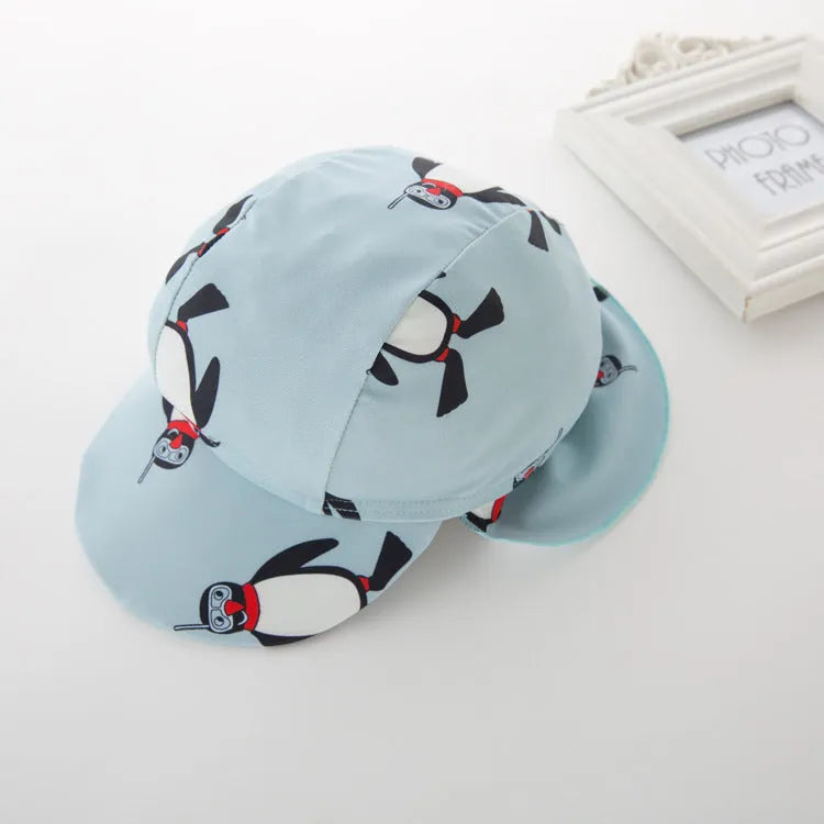 Boys' long-sleeve penguin print swimsuit set with matching swimming cap on mannequin