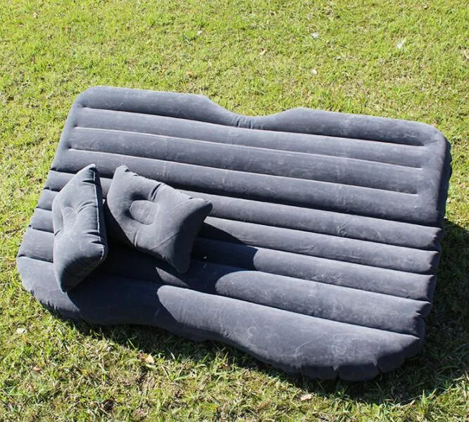 Black inflatable car bed with pillows, set up in the back of a five-seater car.