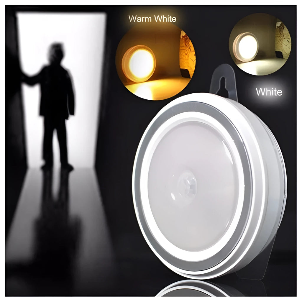 Round white motion sensor LED light unit with battery compartment, 80mm diameter.