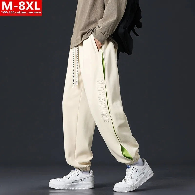 Men's loose-fit cotton trousers with printed stitching detail and ankle banding in grey green colour
