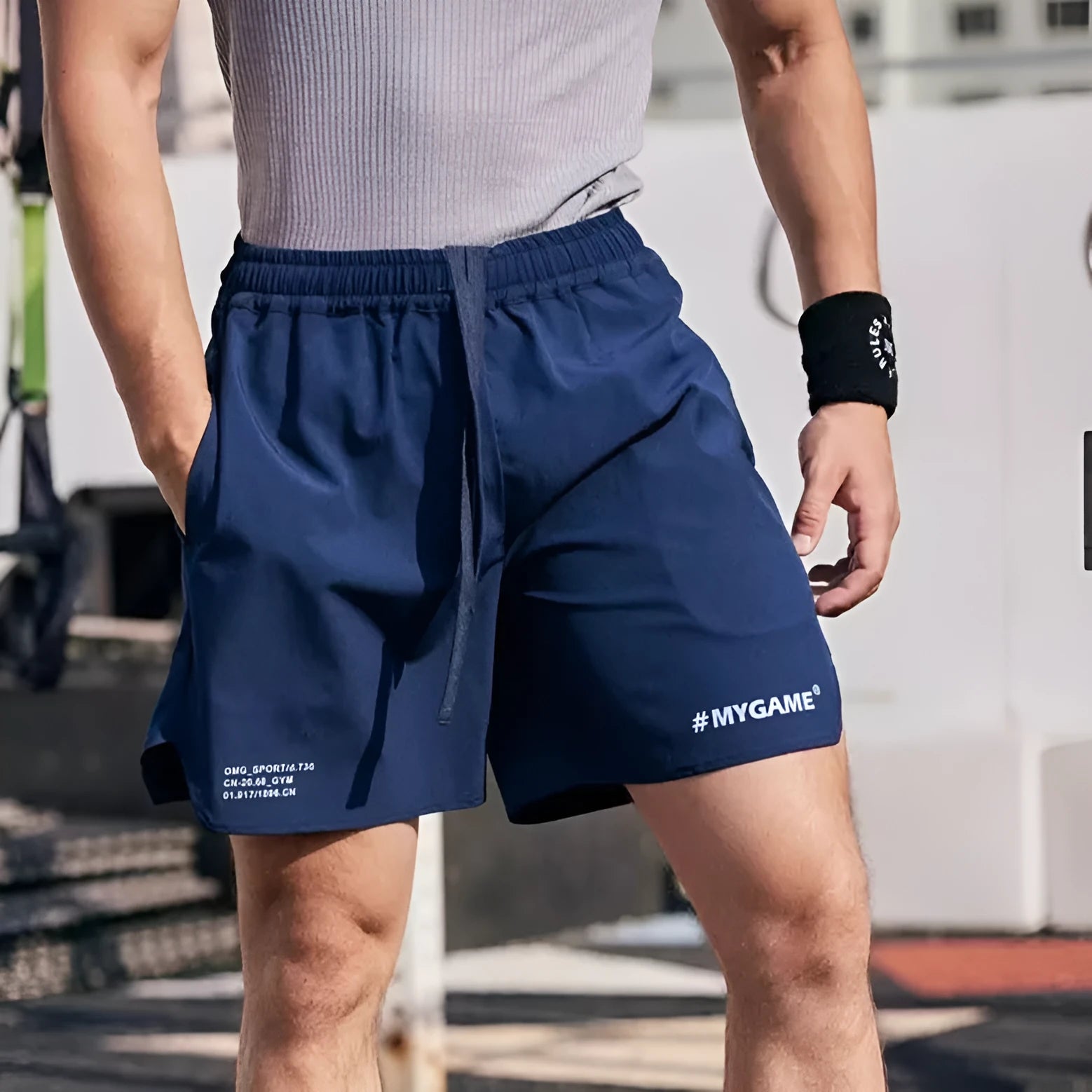Men's grey fitness training shorts with four-point design on a gym floor