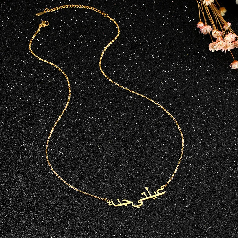 Custom Arabic name necklace in stainless steel with gold plating on a white background