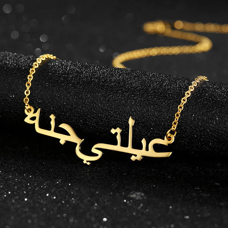 Custom Arabic name necklace in stainless steel with gold plating on a white background