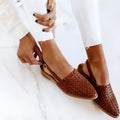 Women's black baotou flat sandals with a buckle strap and pointed toe on a rubber sole.