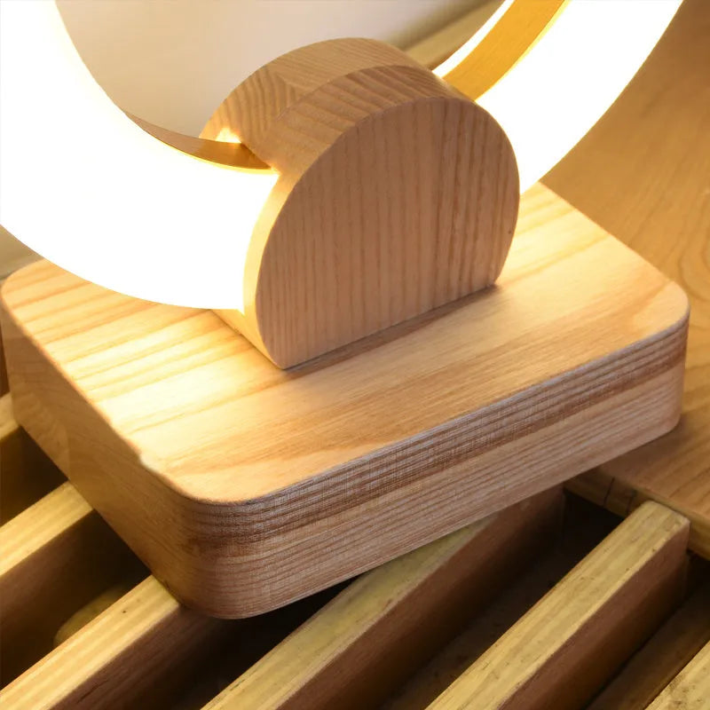 Modern wooden circular chandelier with a white acrylic shade hanging from a ceiling.