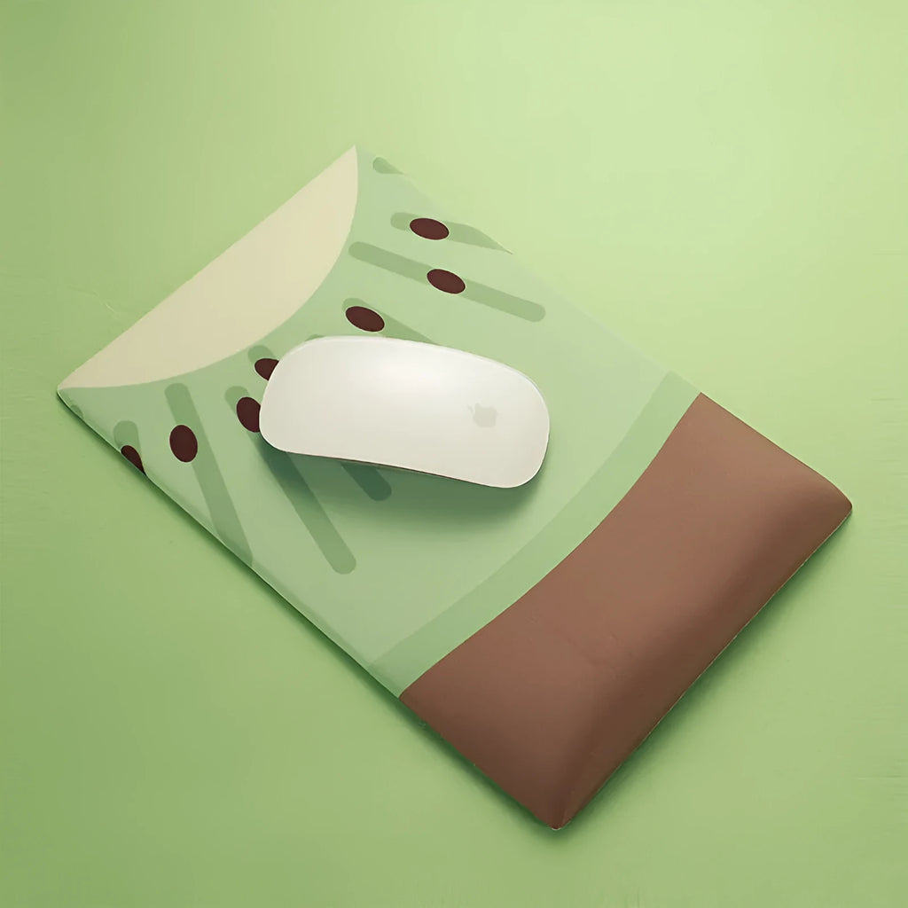 Green kiwi fruit shaped soft gel wrist support mouse pad on a desk.