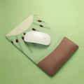 Green kiwi fruit shaped soft gel wrist support mouse pad on a desk.